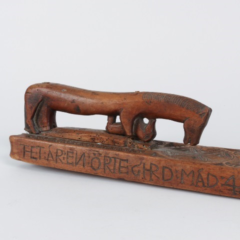 Detail of an archaic Swedish mangle board with the unusual presence of a foal carved under the horse-shaped handle, dated 1731 (private collection)