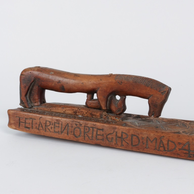 Detail of an archaic mangle board from Sweden with the unusual presence of a foal carved under the horse-shaped handle, dated 1731 (private collection)